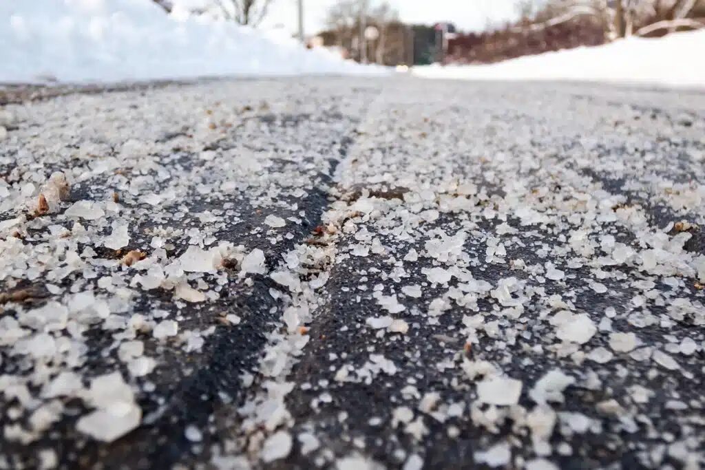 Spreading pet-friendly and eco-friendly ice melt on a walkway in DuPage County Illinois